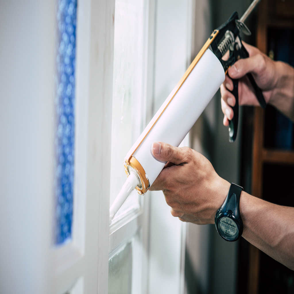 The carpenter holds the glue and attaches to the window